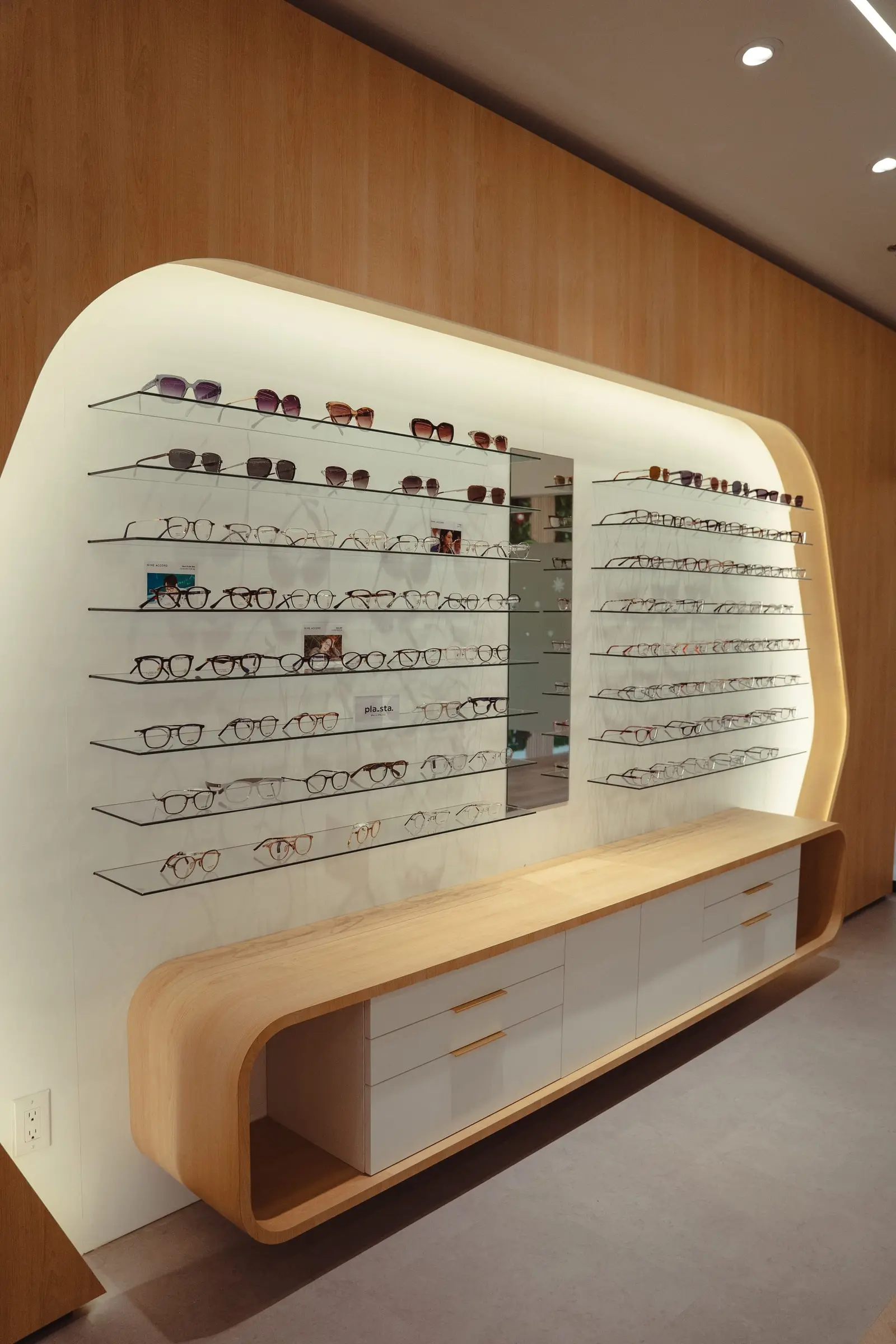 Curved oak eyewear display with glass shelves