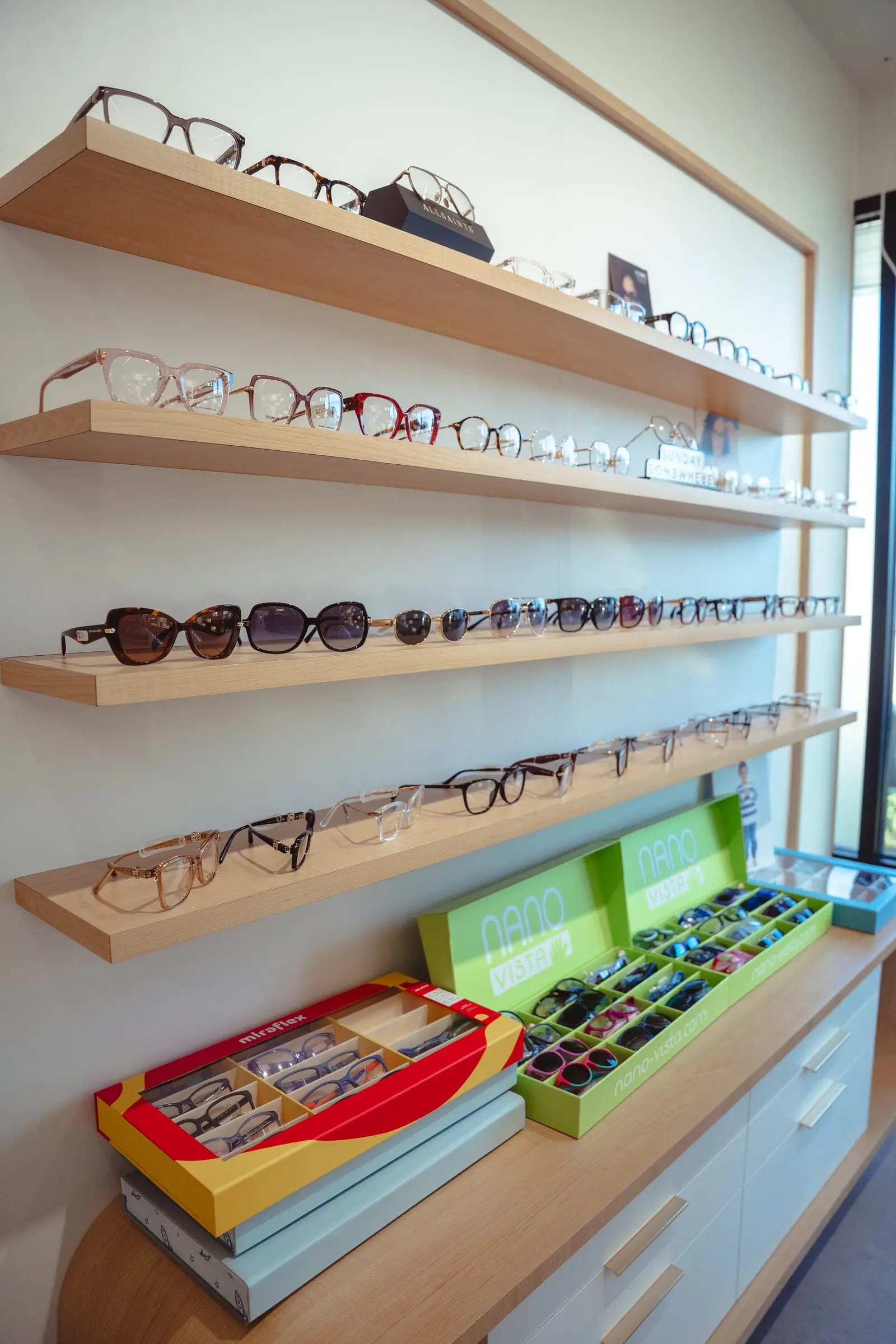 Sunglasses and kids frames on oak shelves