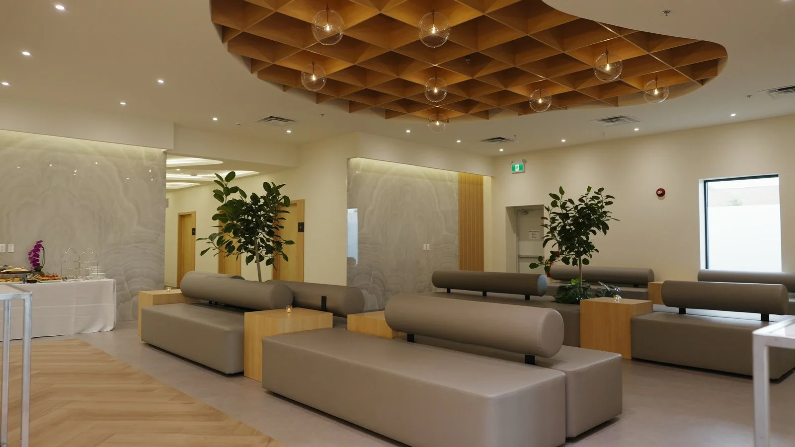The lounge with potted trees and oak side tables