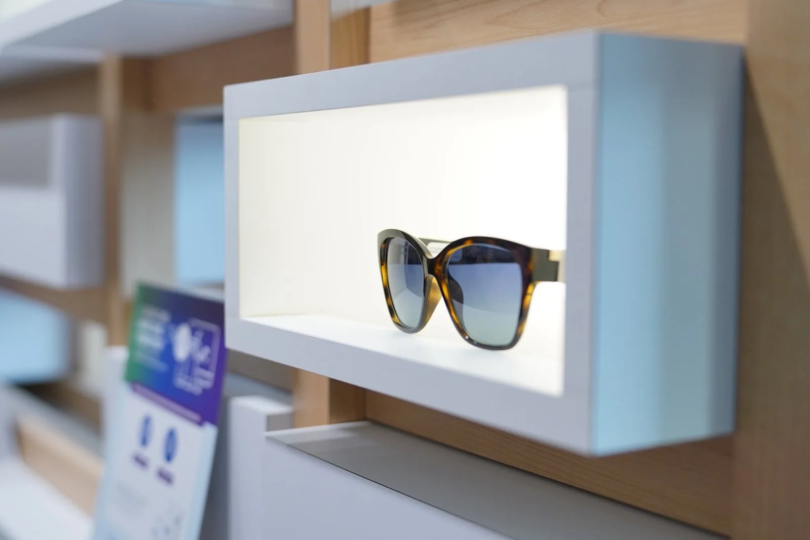 Sunglasses lit in a display niche in the oak wall
